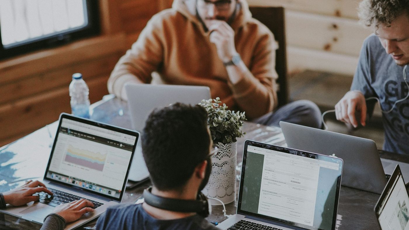 Menschen arbeiten mit Laptops an einem großen Tisch in einem Café in Berlin