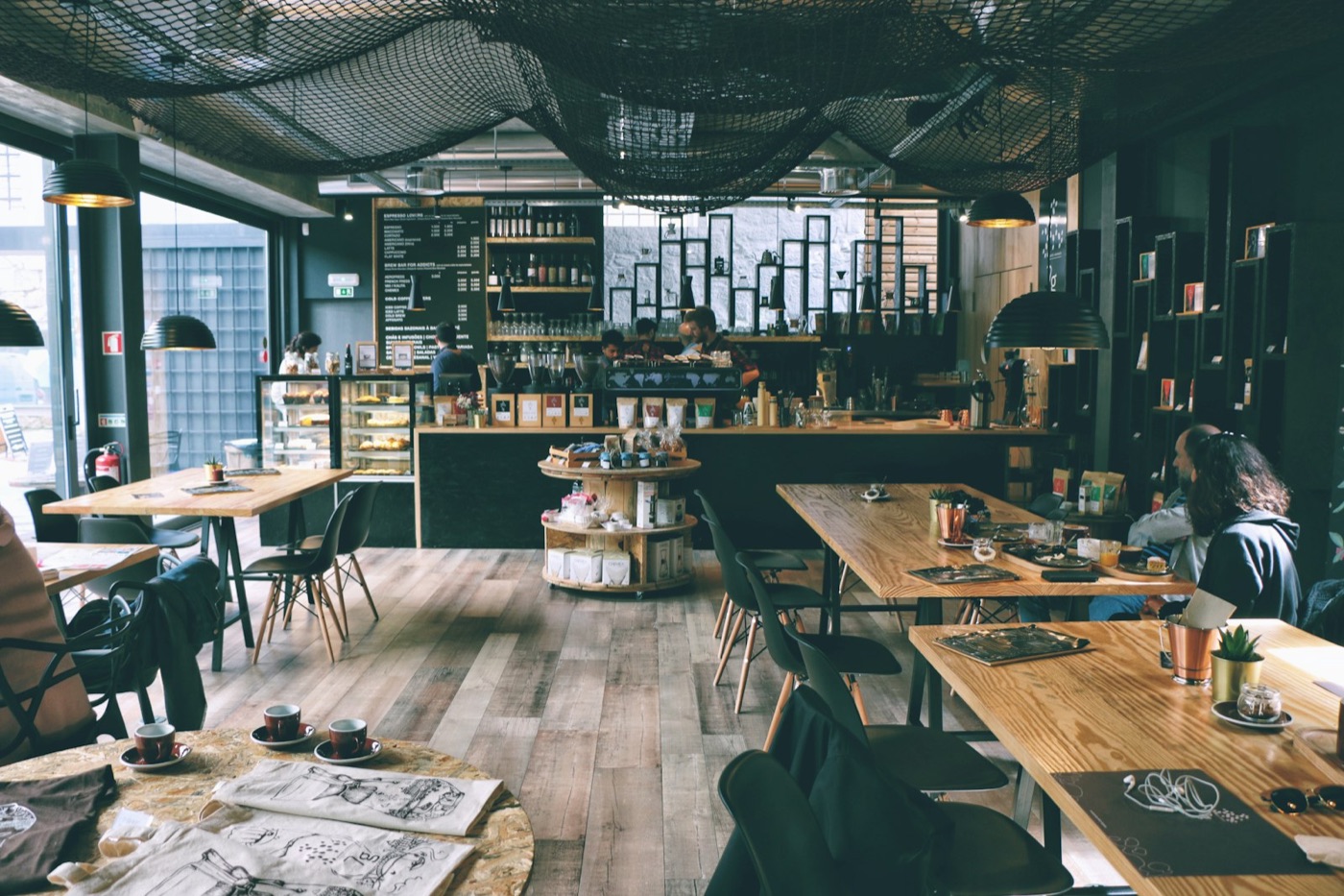 Gemütliches Café in Berlin mit Holztischen und Sitzbereich — stundenweise als Raum buchbar